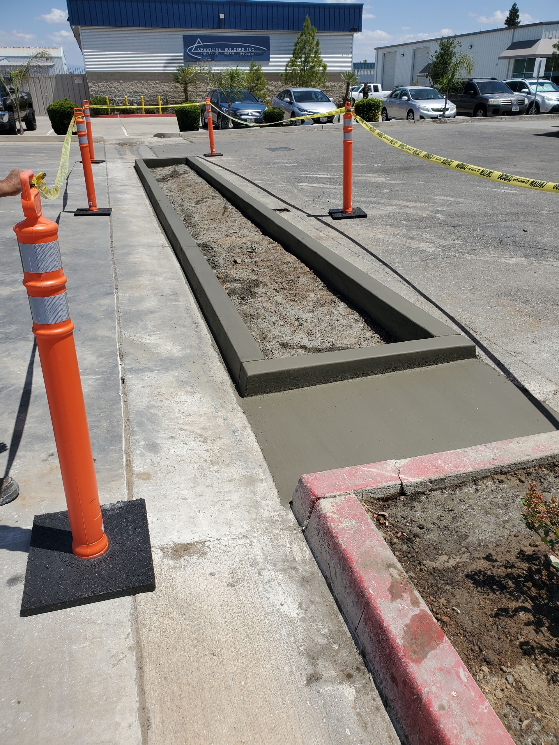 A concrete walkway is being built in a parking lot.