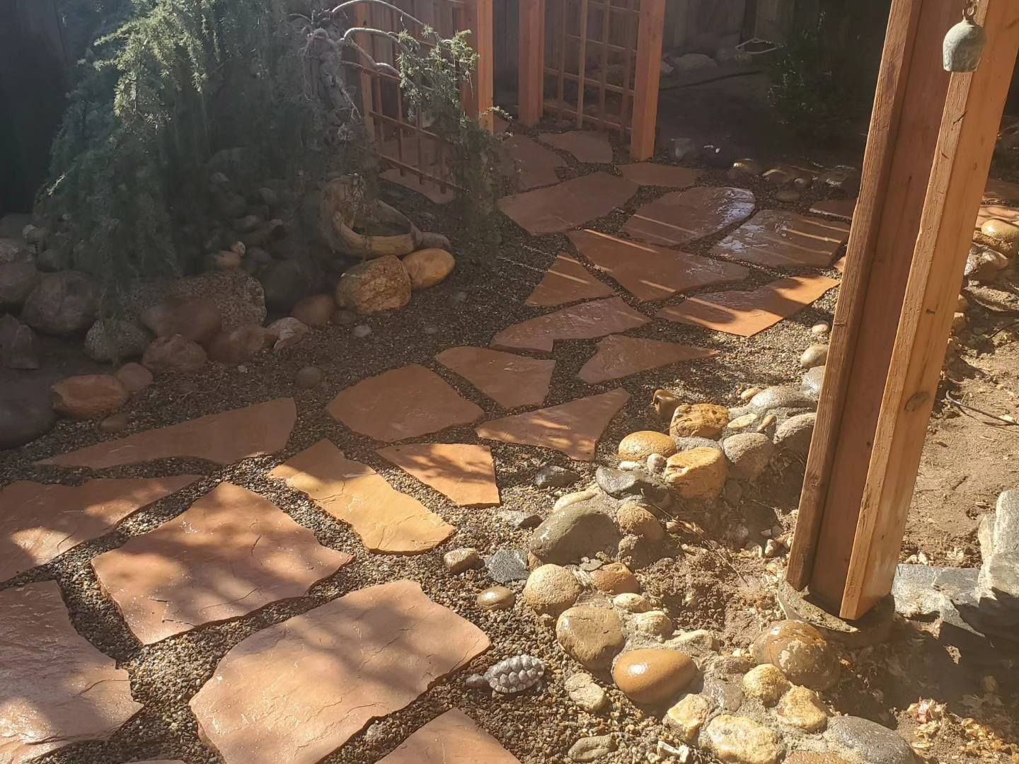 A stone walkway with a wooden post in the middle