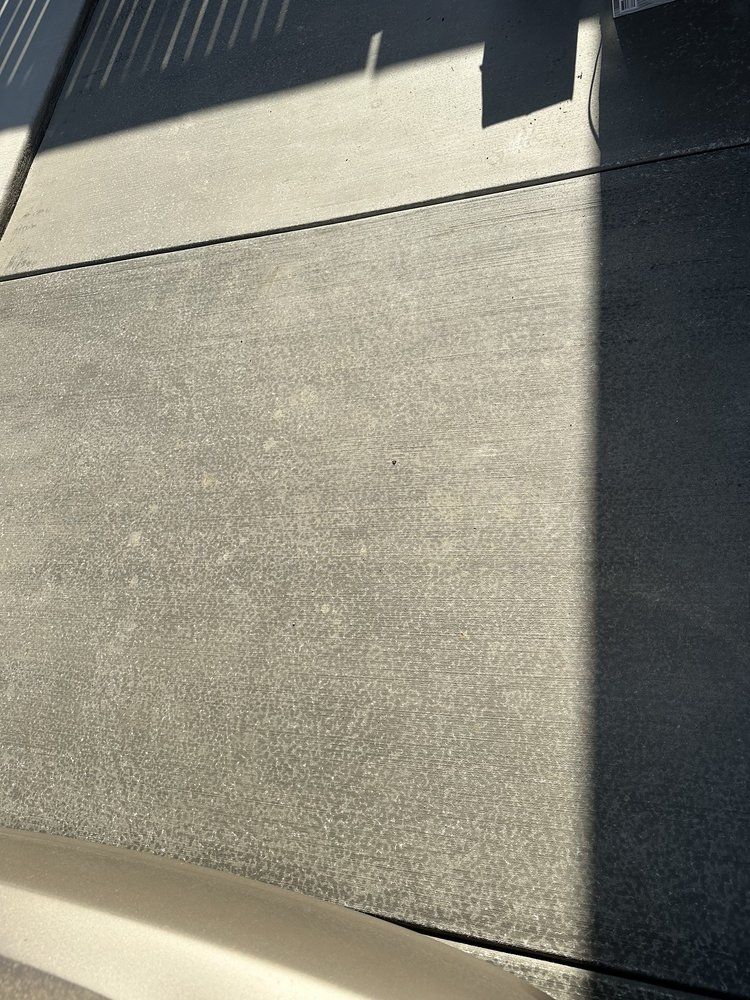 A shadow of a person is cast on a concrete surface.