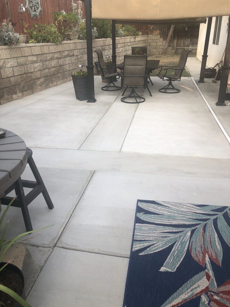 A patio with a table and chairs and a rug