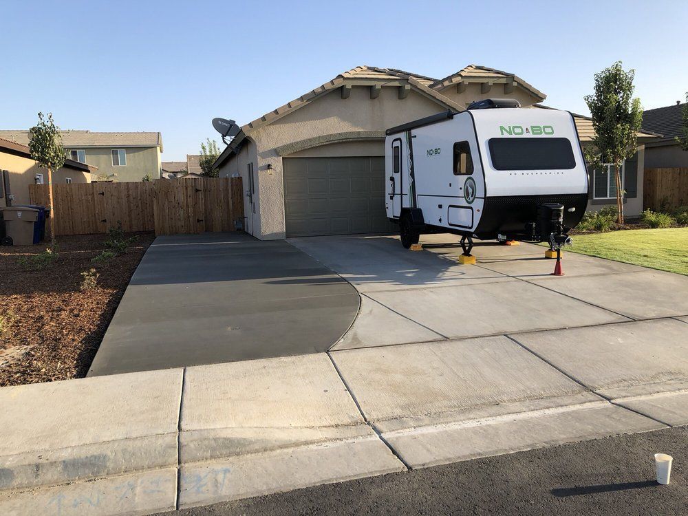 A nomad trailer is parked in front of a house