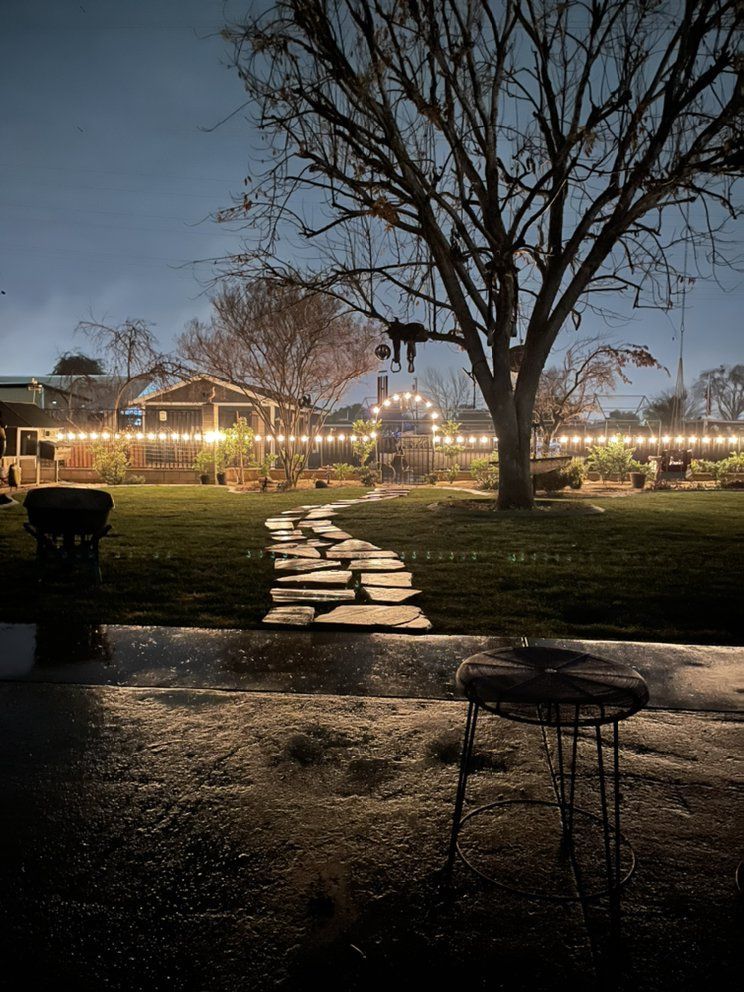 A path leading to a house is lit up at night.