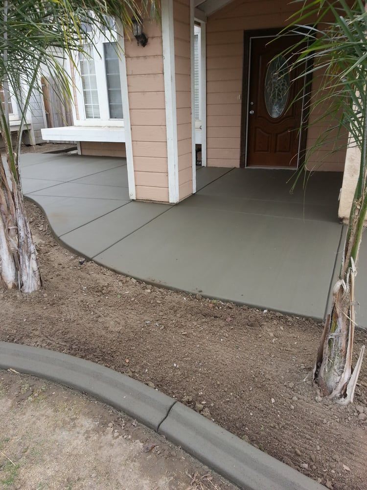 A concrete walkway leading to the front door of a house.