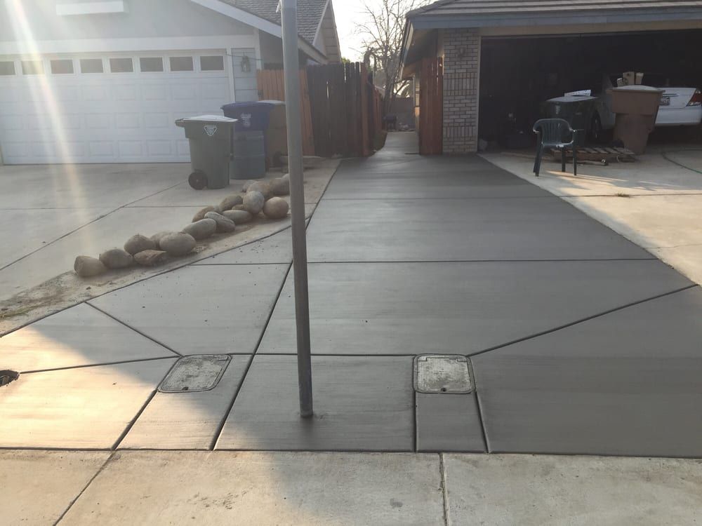 A concrete driveway leading to a garage and a house