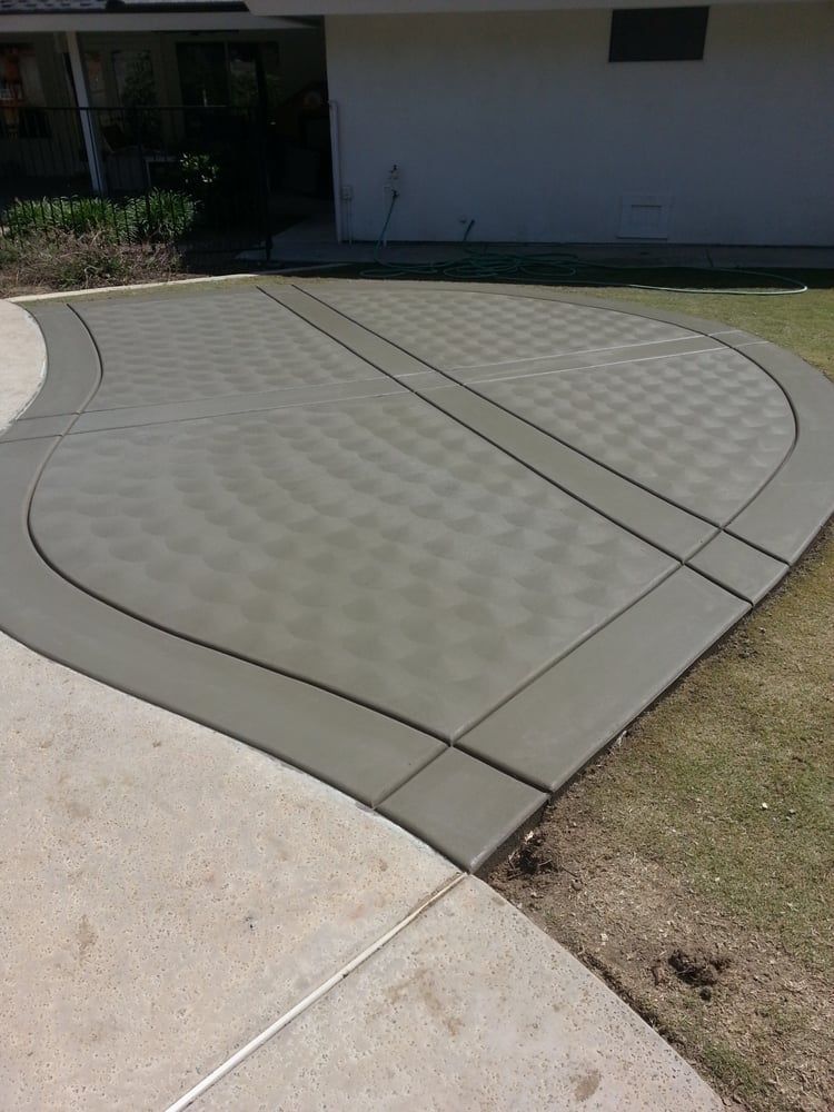 A concrete driveway is being built in front of a house.
