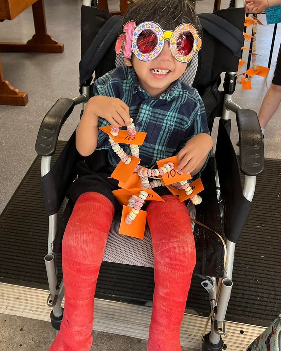 A Young Boy With A Cast On His Leg Is Sitting In A Wheelchair — Tailored Support Services Pty Ltd In Maroochydore, QLD