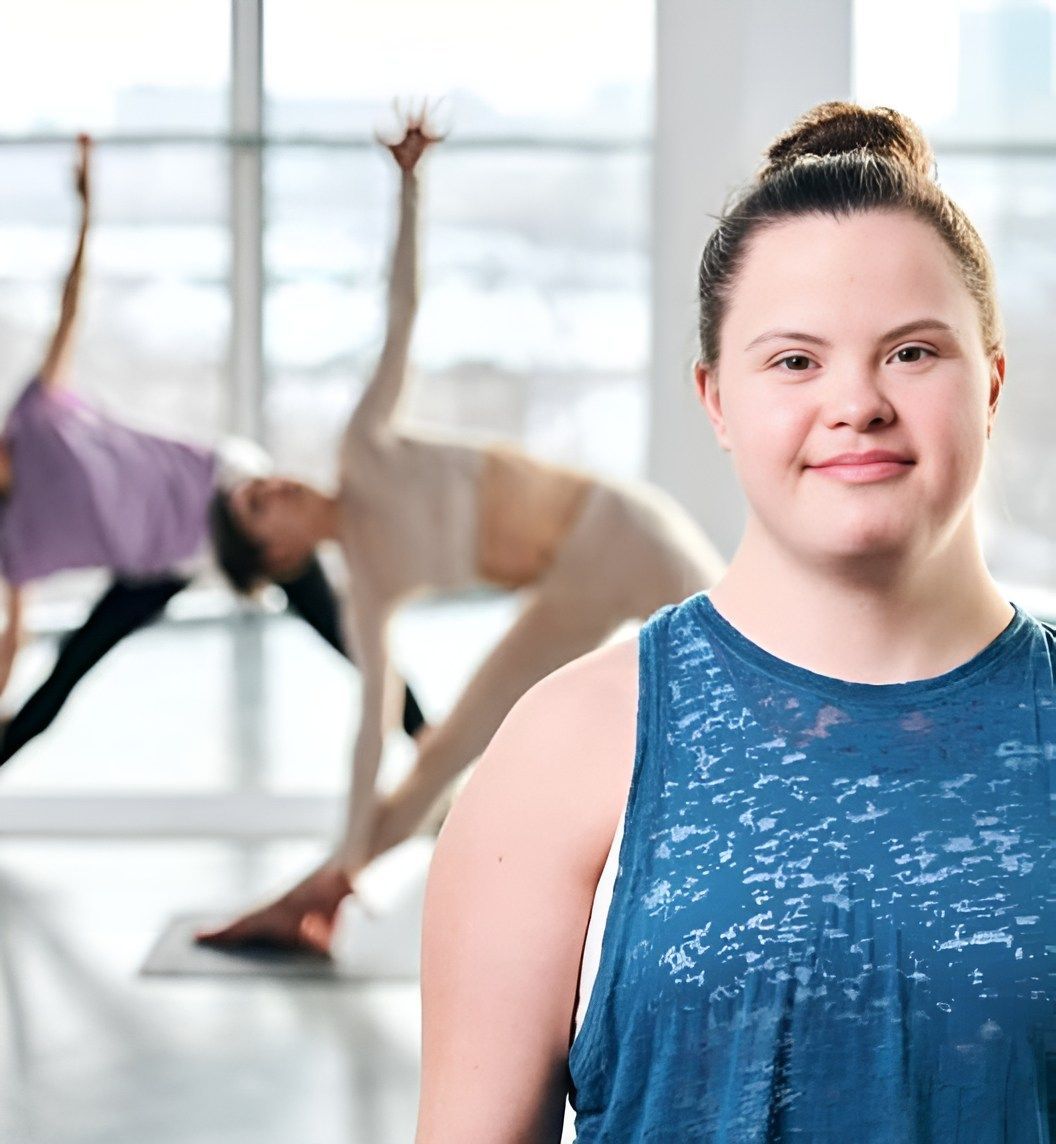 A Woman Is Standing In Front Of A Group Of Women Doing Yoga — Tailored Support Services Pty Ltd In Noosa, QLD