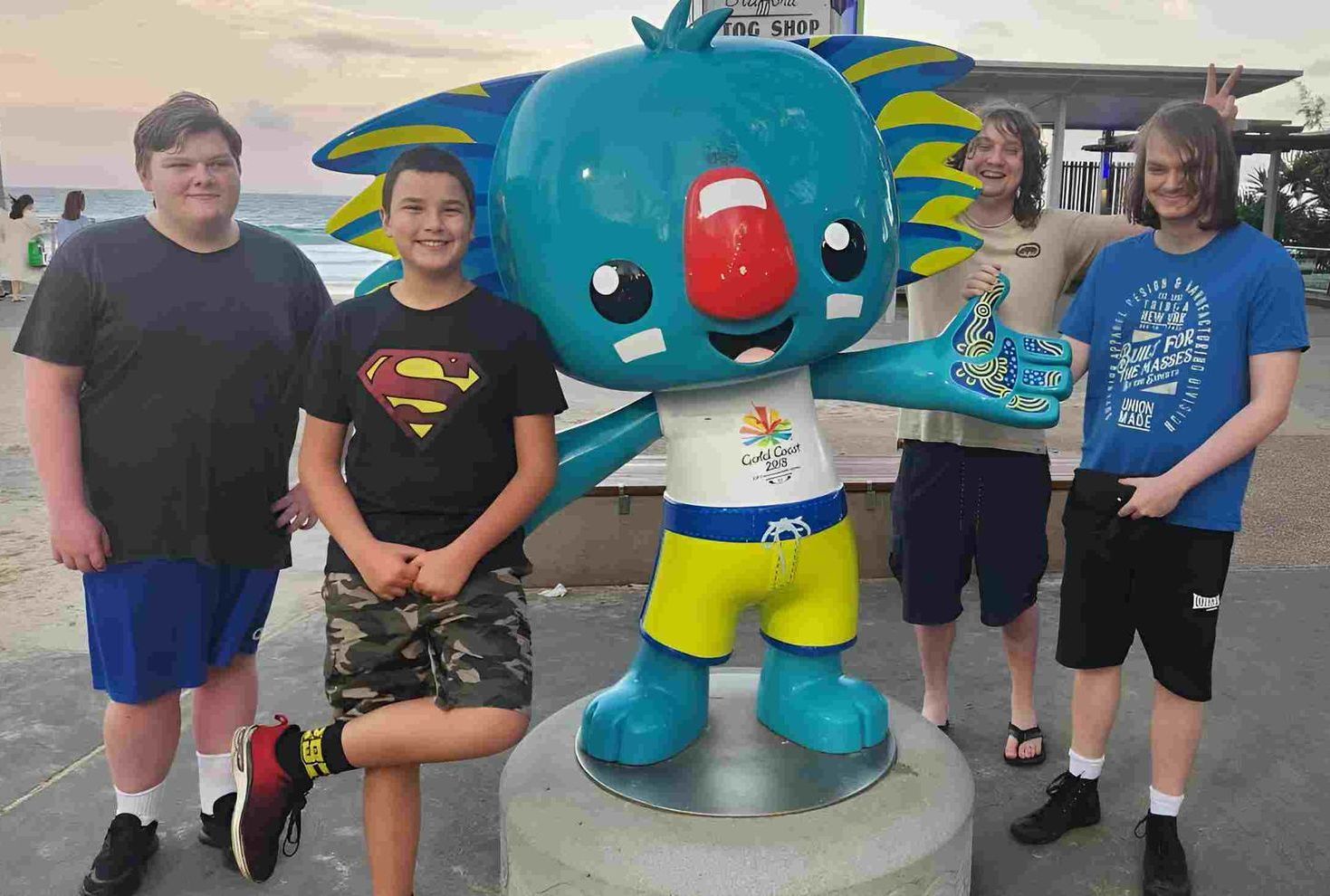 A Group Of Young Men Standing Next To A Statue Of A Koala — Tailored Support Services Pty Ltd In Maroochydore, QLD
