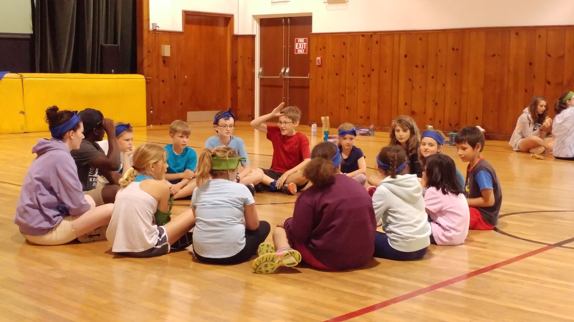 A group of children are sitting in a circle on the floor