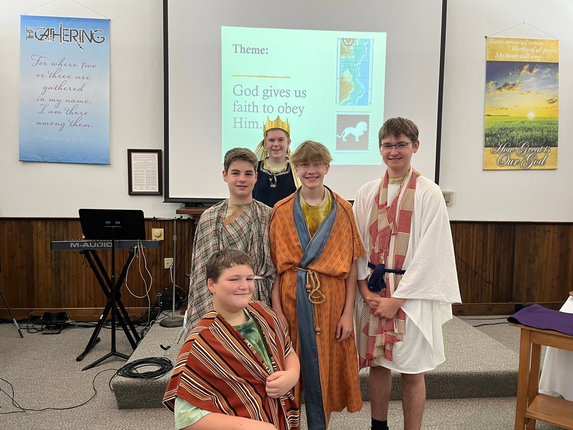 A group of young boys are posing for a picture in front of a projector screen that says item