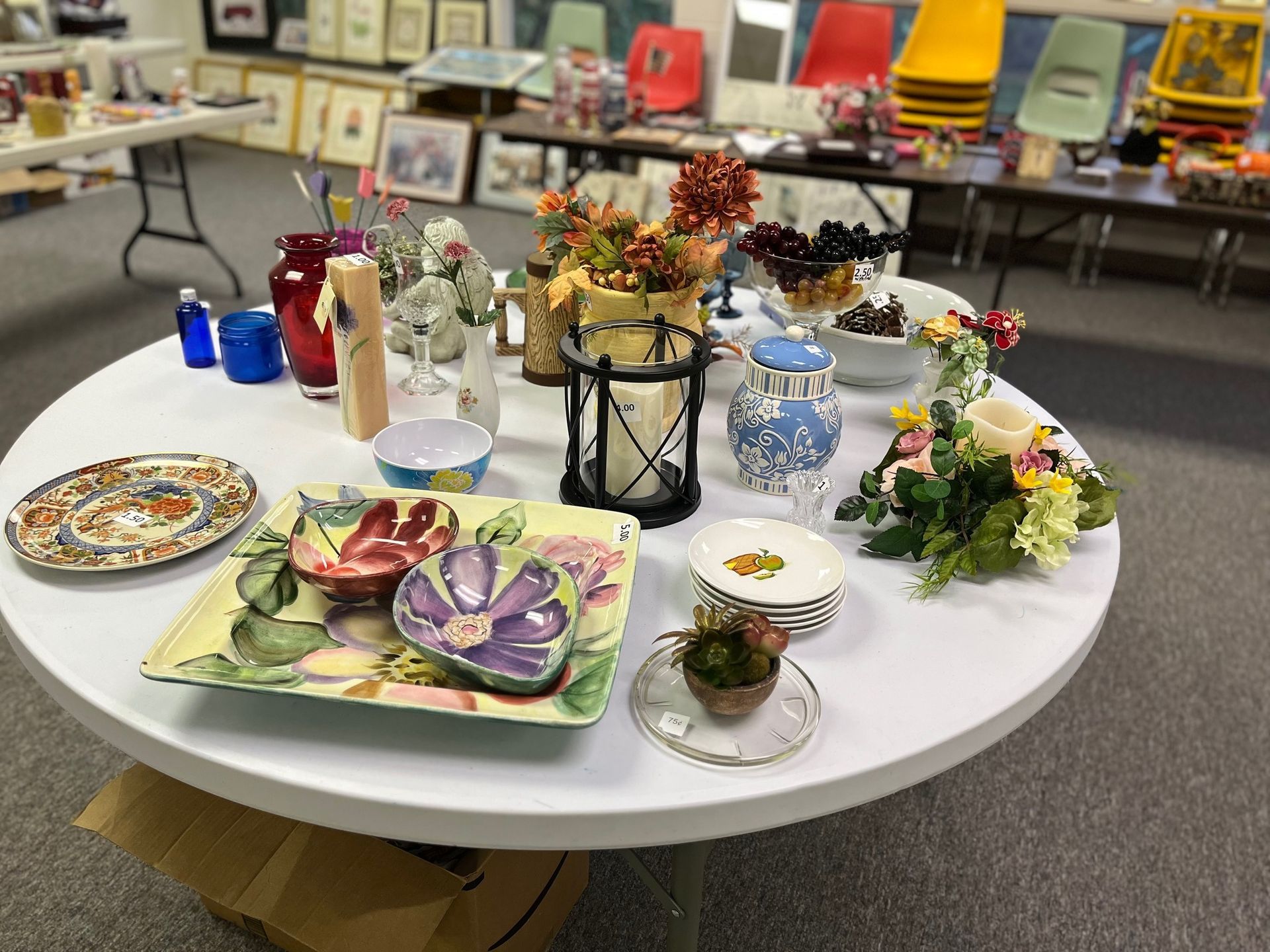 A table with plates vases and flowers on it
