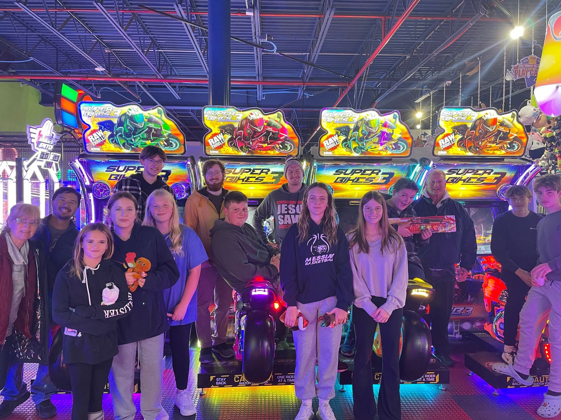A group of people are posing for a picture in an arcade.