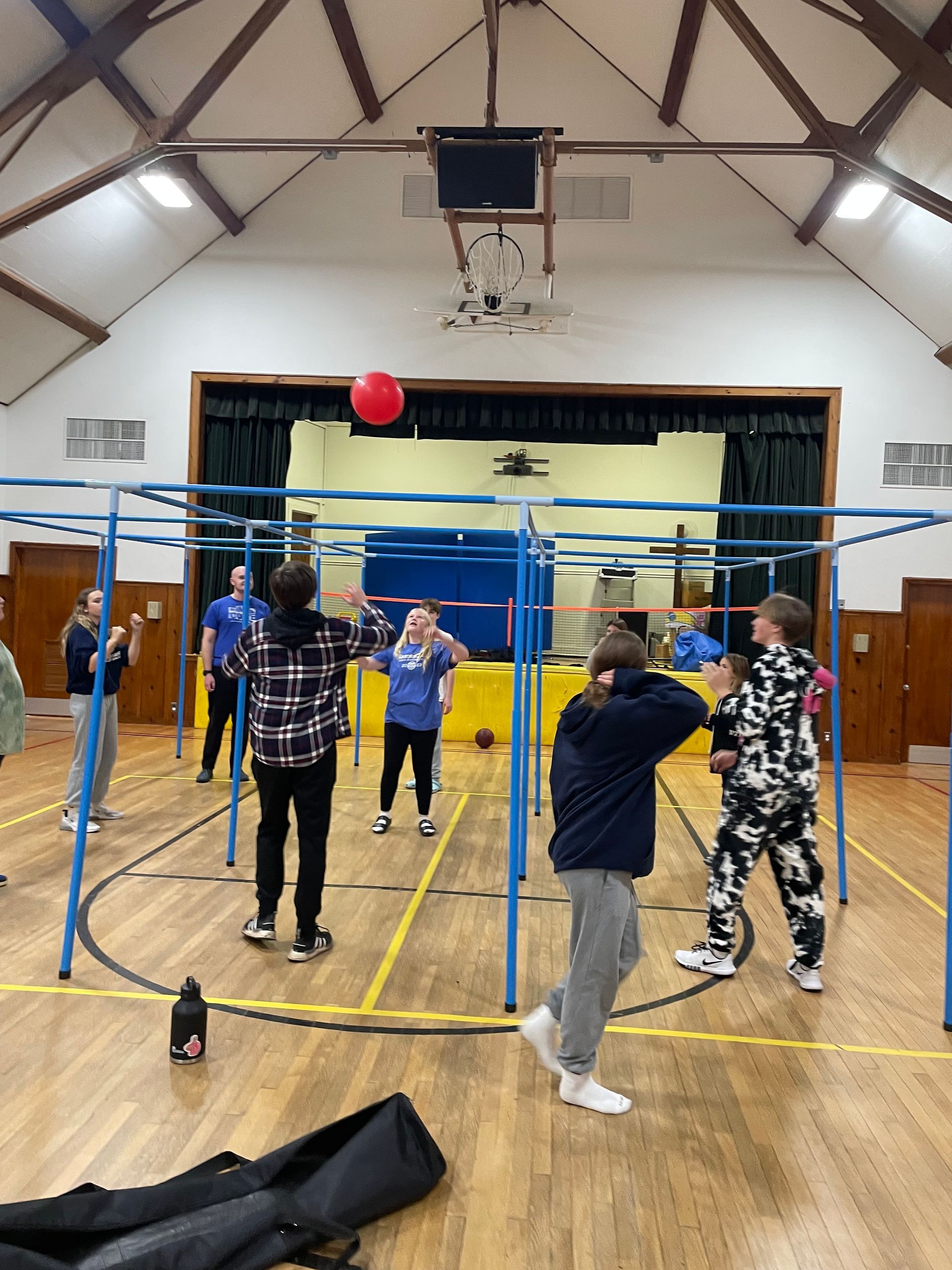 A group of people are playing volleyball in a gym