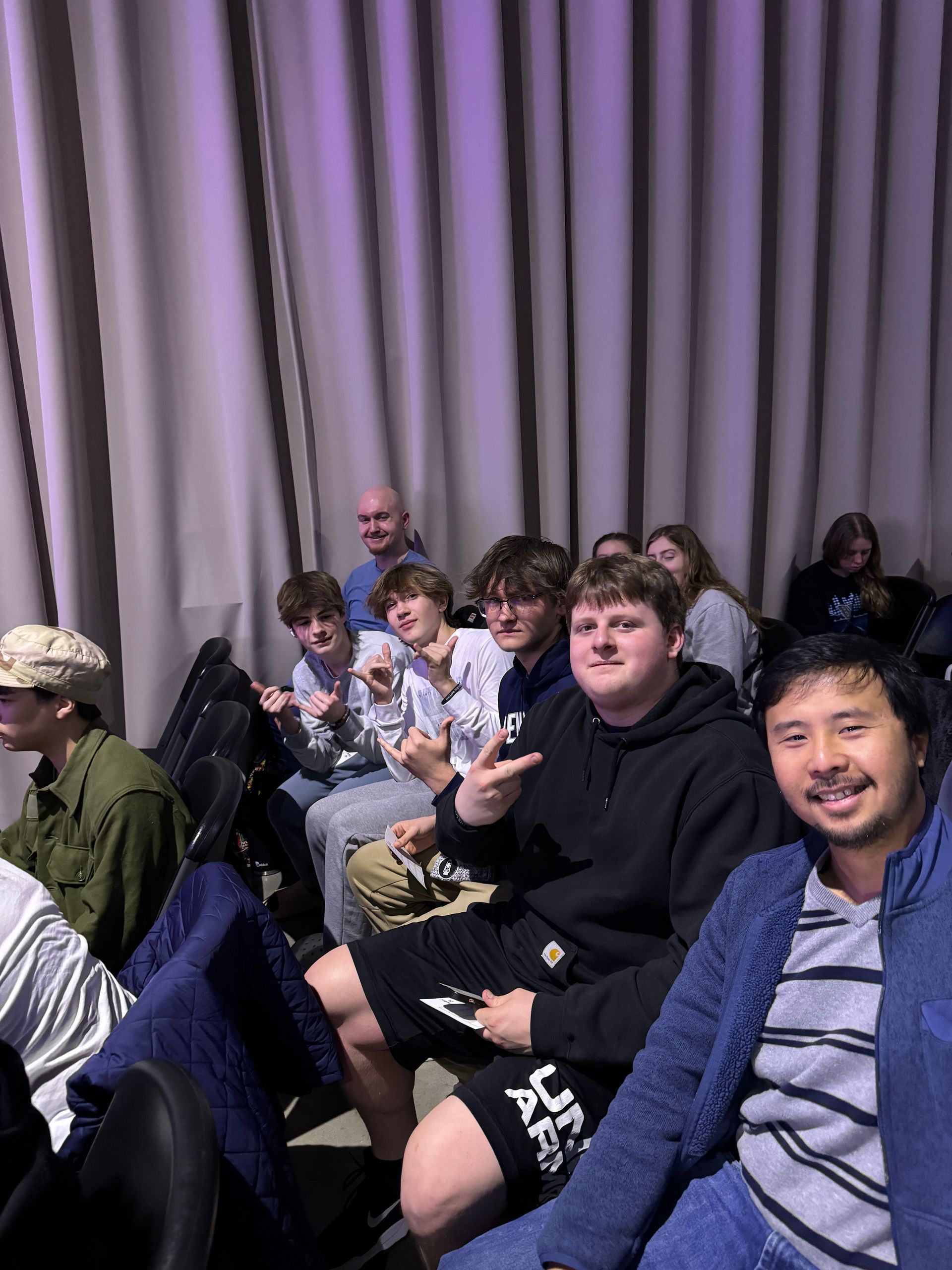 A group of young people are sitting in a theater watching a movie.