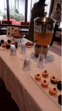 A table with a drink dispenser and cupcakes on it.