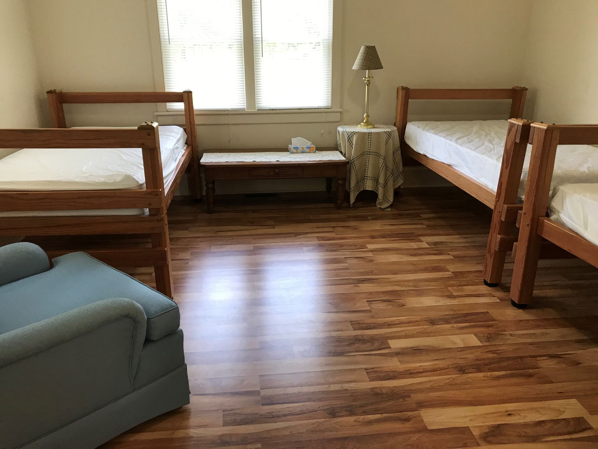A bedroom with two bunk beds and a blue chair