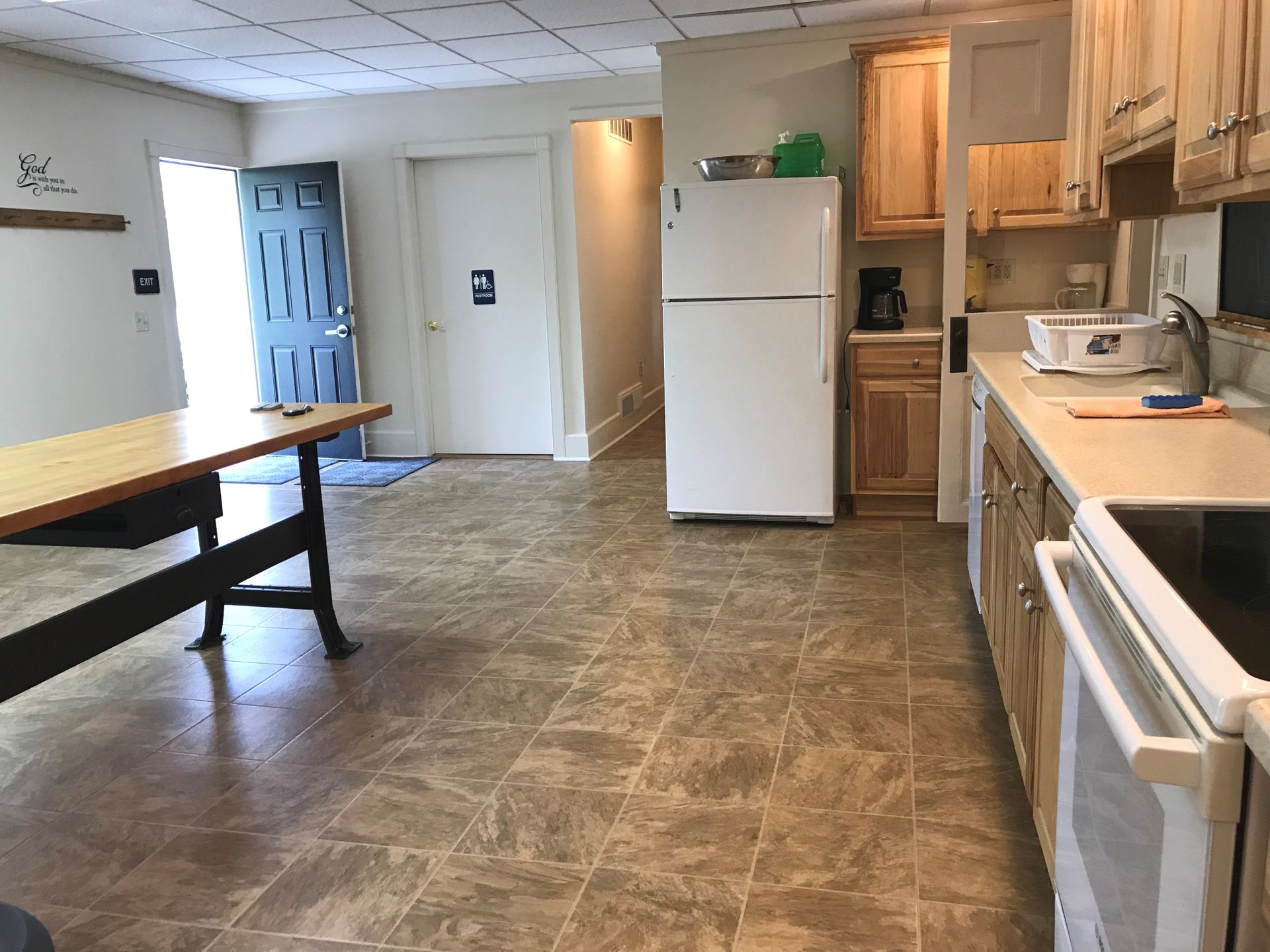 A kitchen with a white refrigerator and wooden cabinets