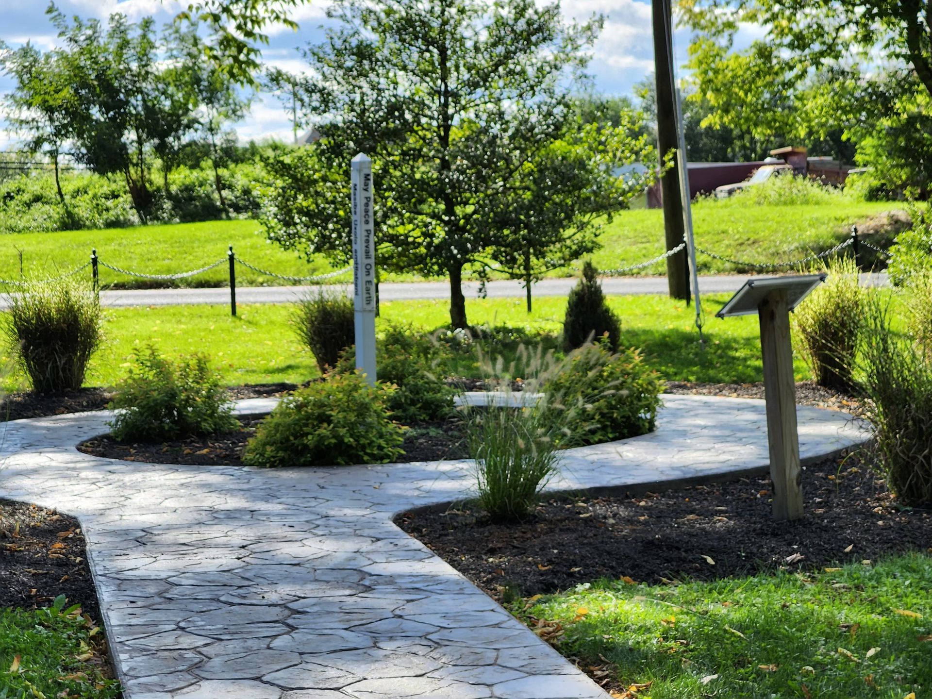 A walkway in a park with a sign that says ' memorial ' on it