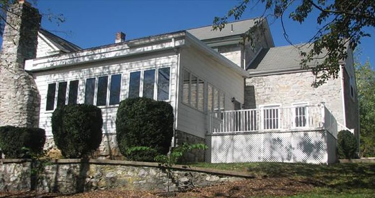A large white house with a porch and a chimney