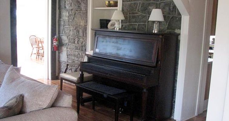 A living room with a piano and a couch