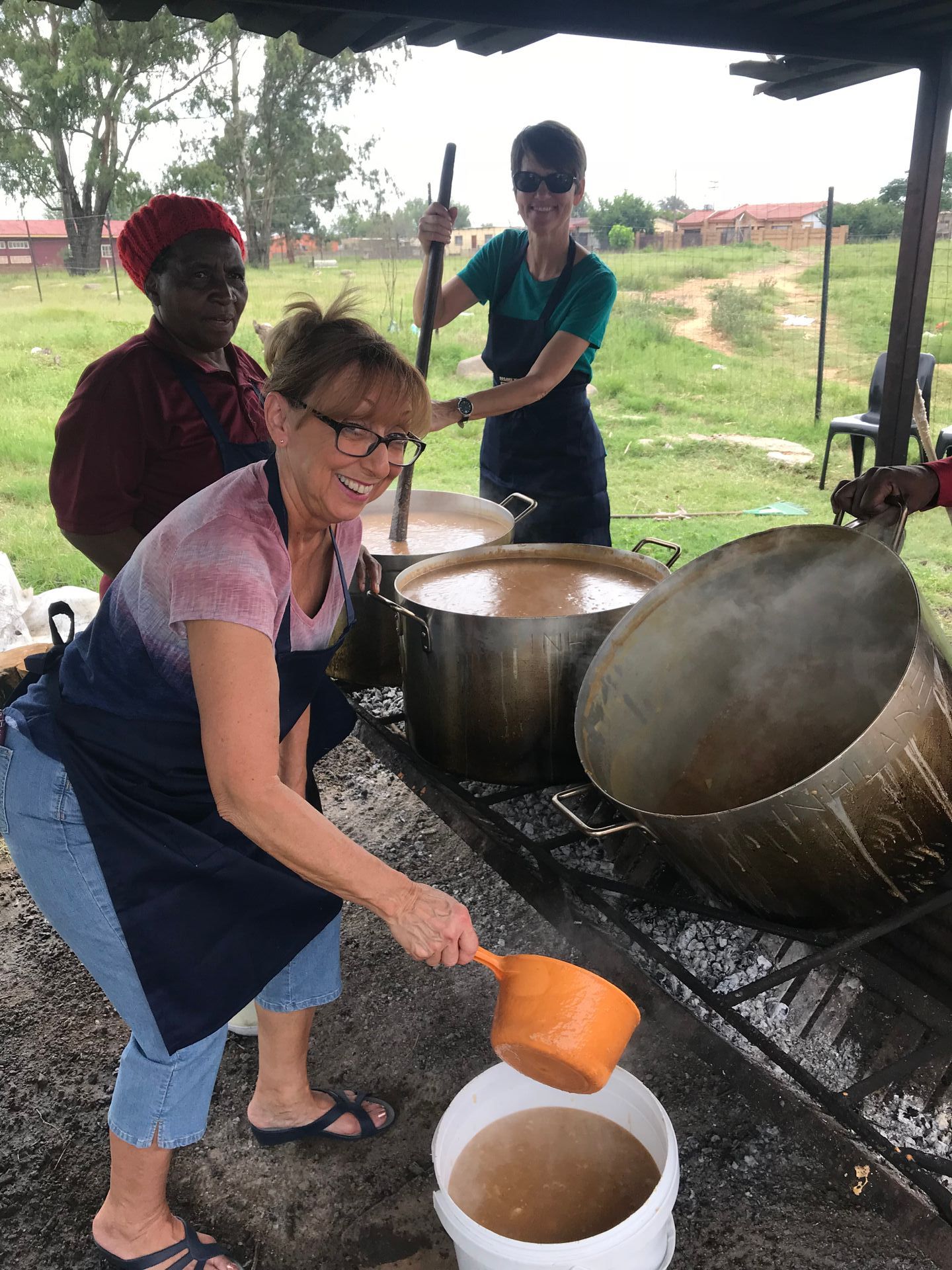 A woman is pouring something into a white bucket