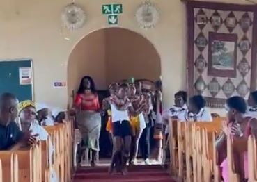 A group of people are walking down the aisle of a church.