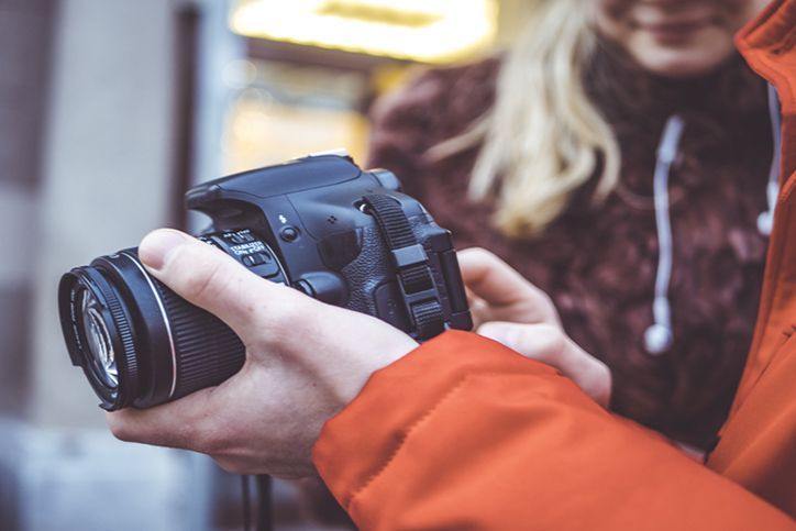 photo camera dslr in the man's hands in the street