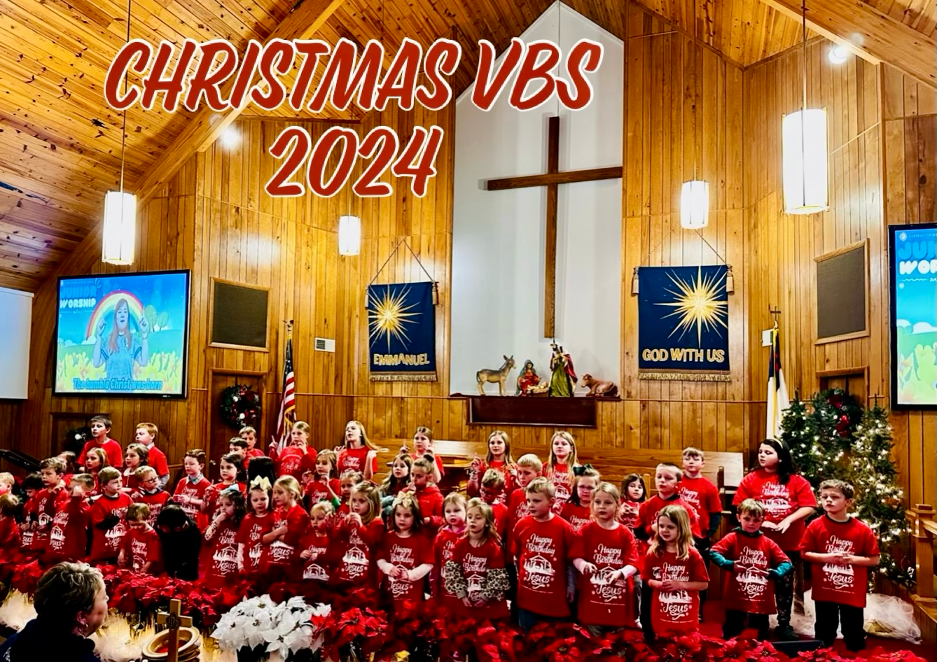 Christmas VBS 2024: Children in red shirts in church, a wooden cross, and decorations.