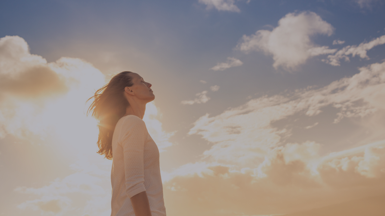 Woman standing in the sun and reflecting on life's lessons. Feeling the power of self-reflection