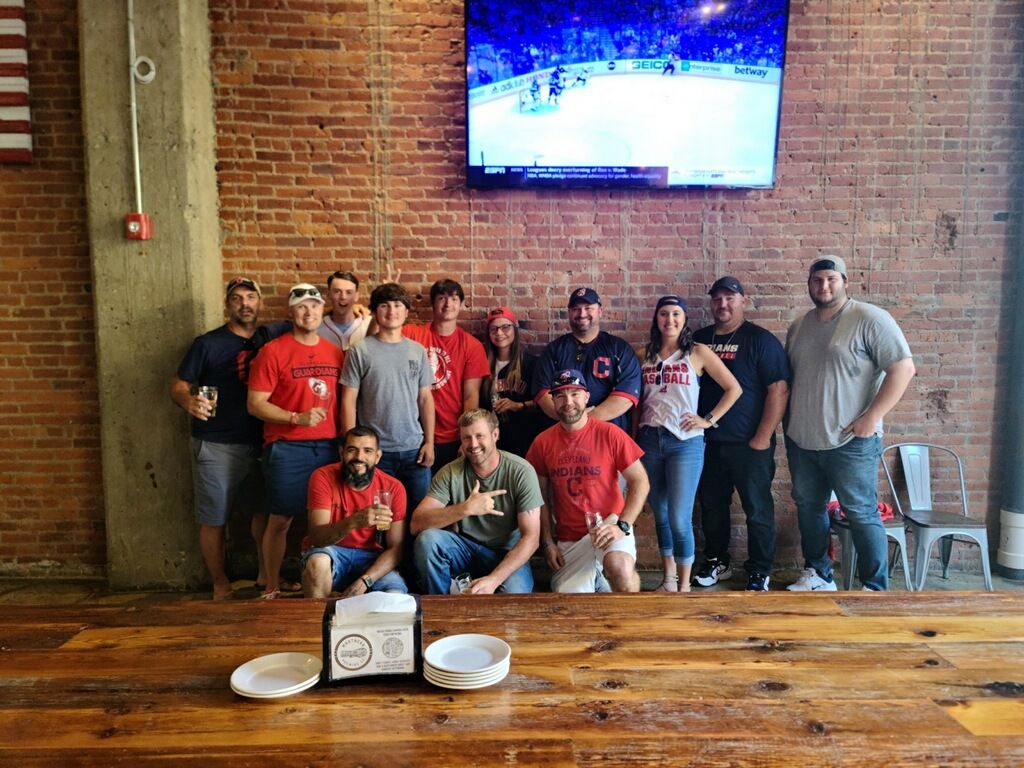 A group of people are posing for a picture in front of a television.