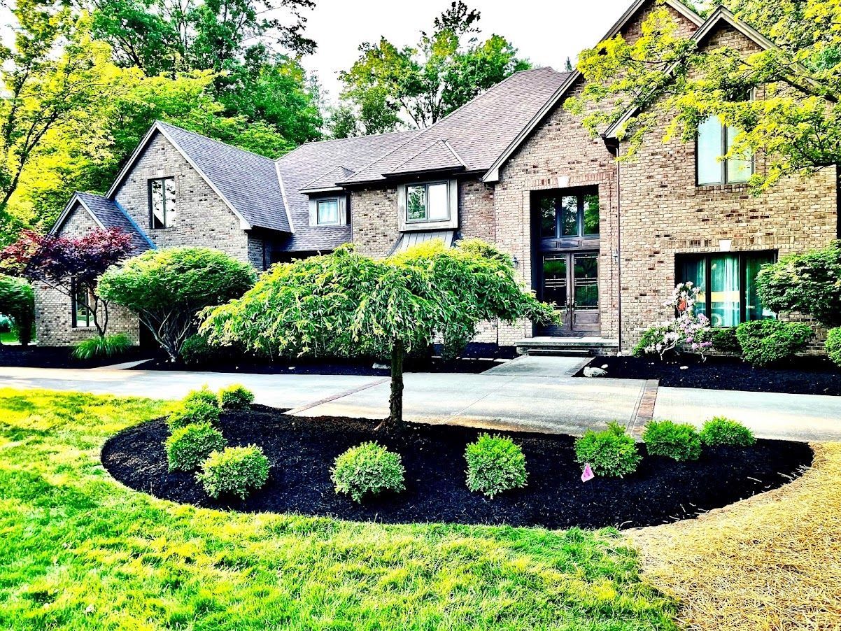 A large brick house with a tree in front of it