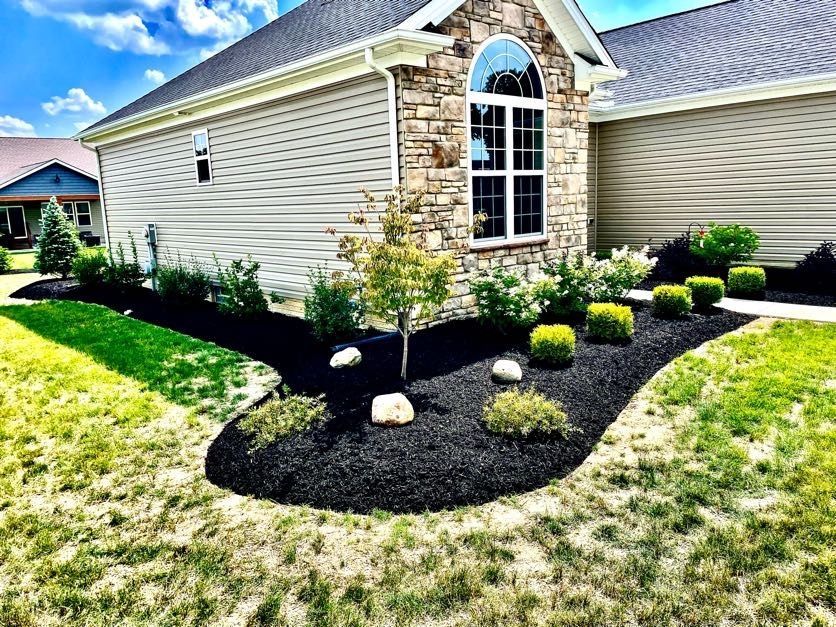 A house with a lot of landscaping in front of it.