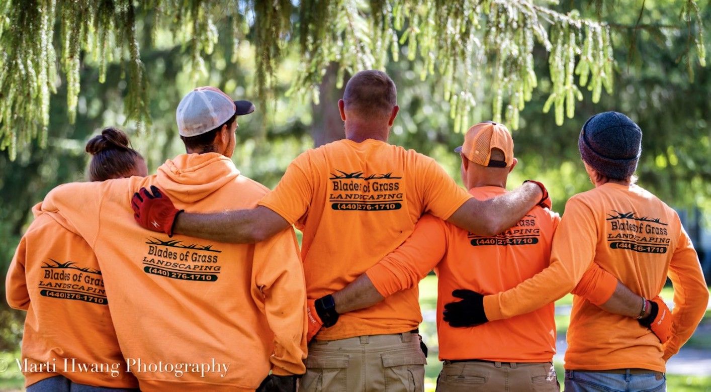 A group of people standing next to each other with their arms around each other.