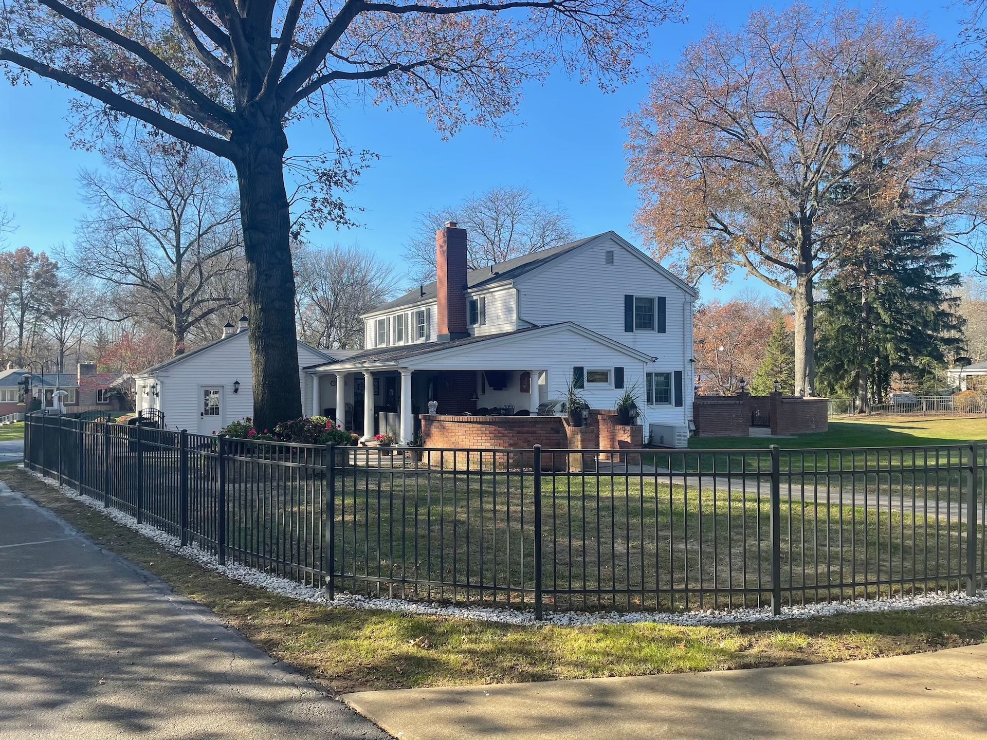 A white house with a black fence around it.