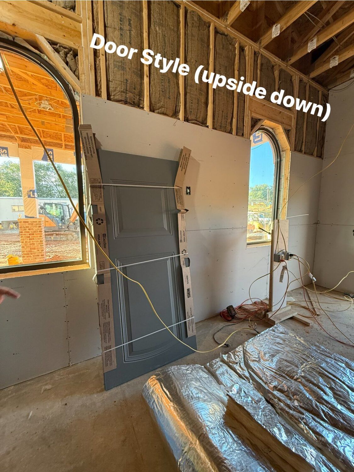 Interior of a building under construction, showing a door frame and drywall.