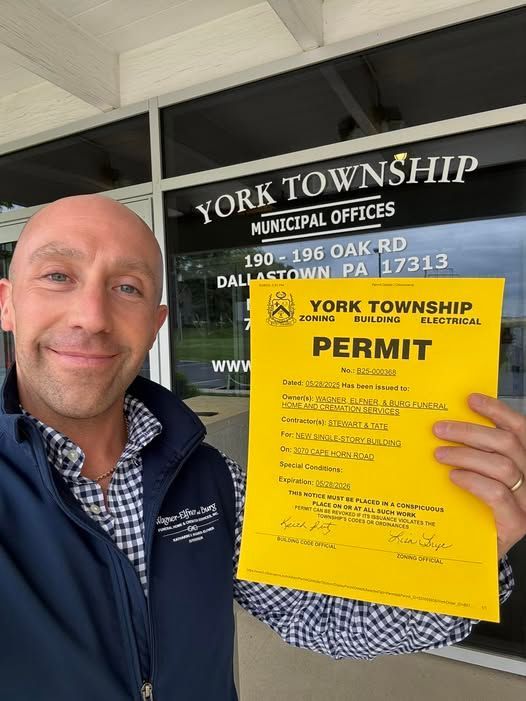 Man holding a yellow permit in front of York Township Municipal Offices in Dallastown, PA.