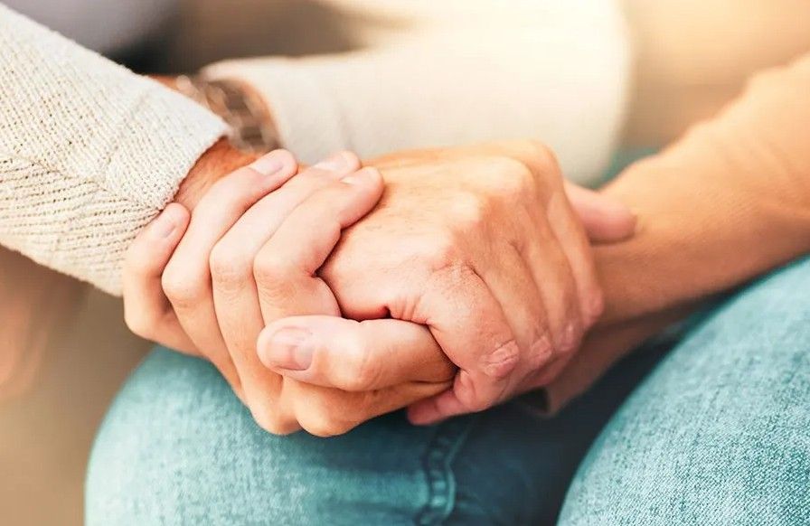 Close-up of hands offering comfort and support during Dallastown, PA funeral and cremation services