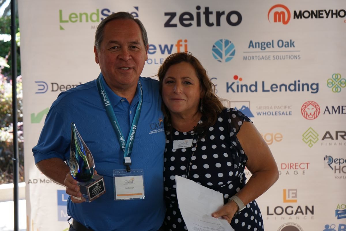 Award presented in front of the sponsor wall