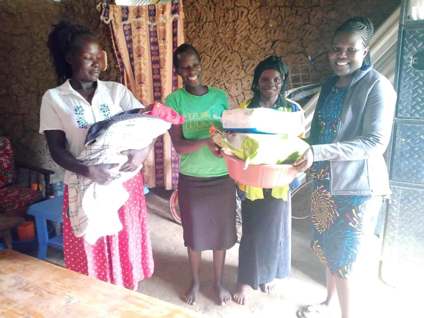 Four people holding donations of clothes and a basin indoors.