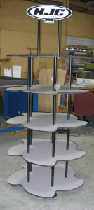 Multi-tier white display stand with black supports and HJC logo in a store showroom