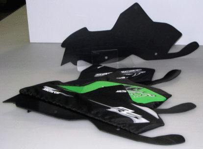 Stacked black and green fabric pouches on a white surface