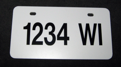 White license plate with black text “1234 WI” on a plain background