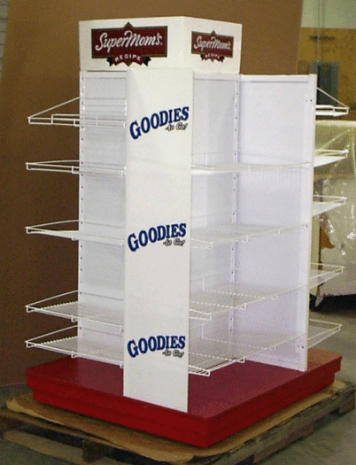 White rotating snack display rack with blue “GOODIES” text and red base on a wooden pallet.