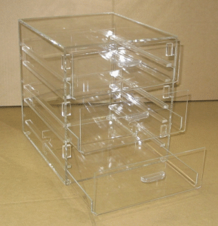 Clear plastic 4-drawer organizer with one drawer open, on a tan surface