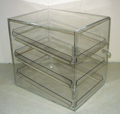 Clear acrylic three-drawer storage organizer with a hinged top, shown on a plain surface.