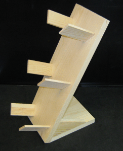 Wooden coat rack with angled shelves and pegs, light wood against a dark background.