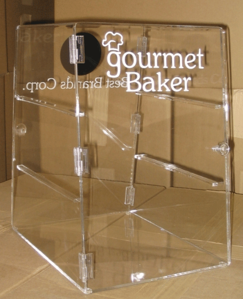 Clear acrylic countertop display box with Gourmet Baker logo on a cardboard background