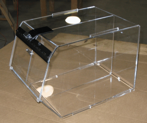Clear plastic display box with a black hinged lid on a beige surface
