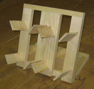Wooden tabletop puzzle with sliding panels and small shelves, shown on a brown surface.