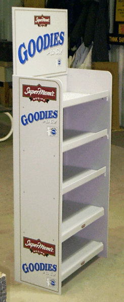 White Goodies candy display stand with empty shelves and blue signage.